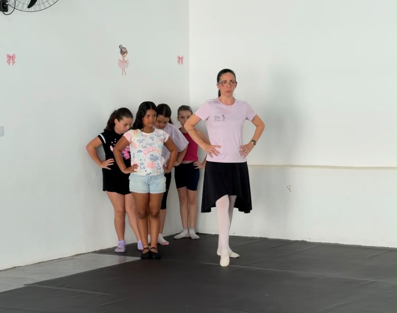 Professora orientando alunas na oficina de ballet